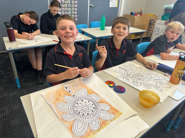 Students in a classroom painting flowers.