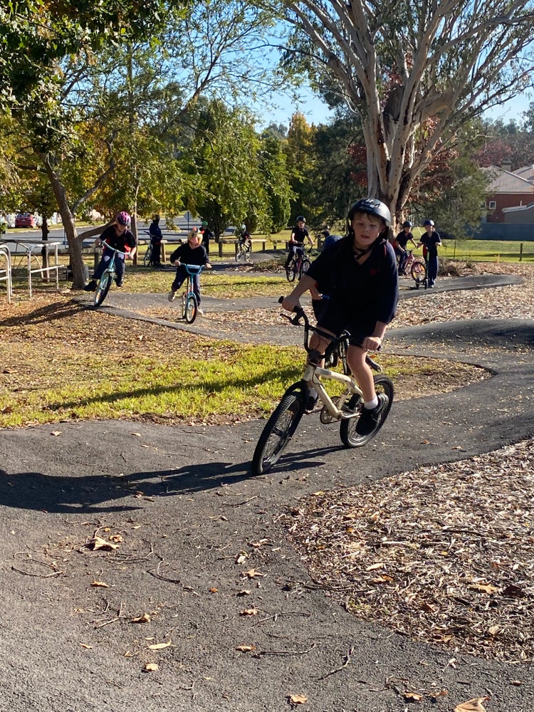 Students riding a bike at the bike track.