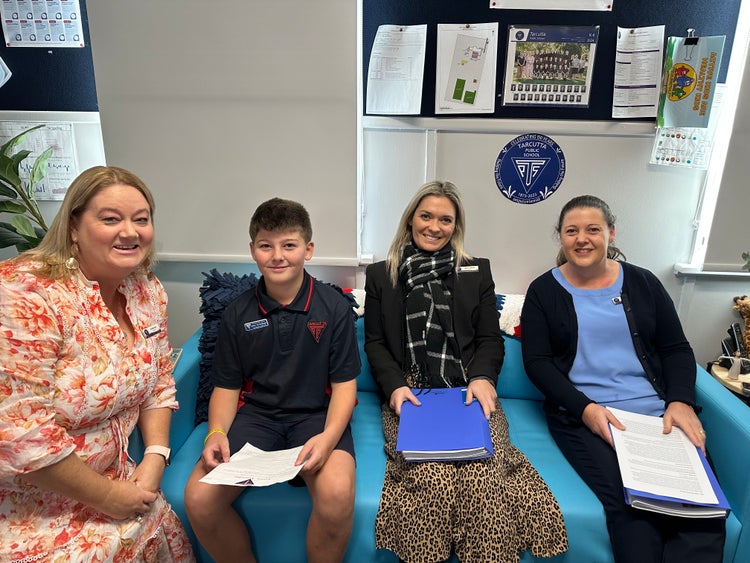The principal, a student and staff in an office.