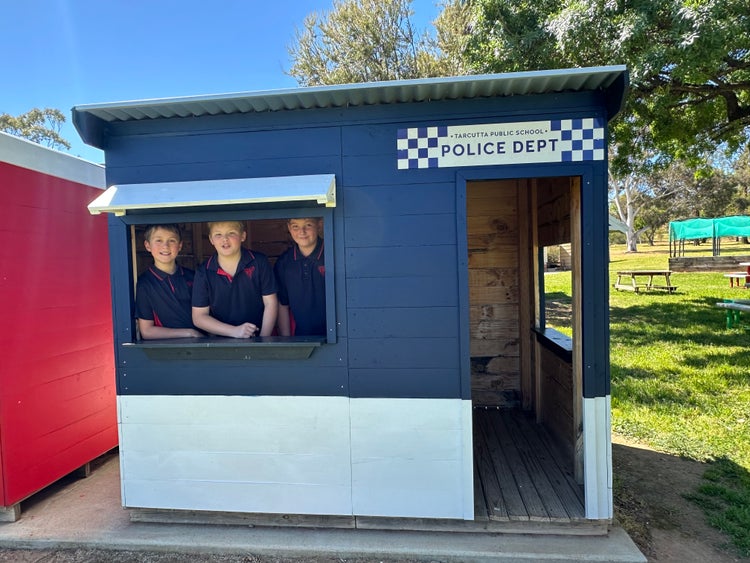 Three students inside the police cubby.